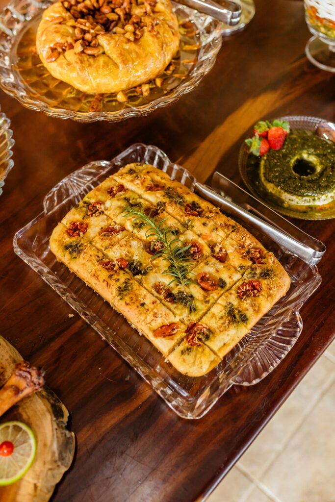 A variety of freshly baked bread and pastries displayed on a rustic wooden table.