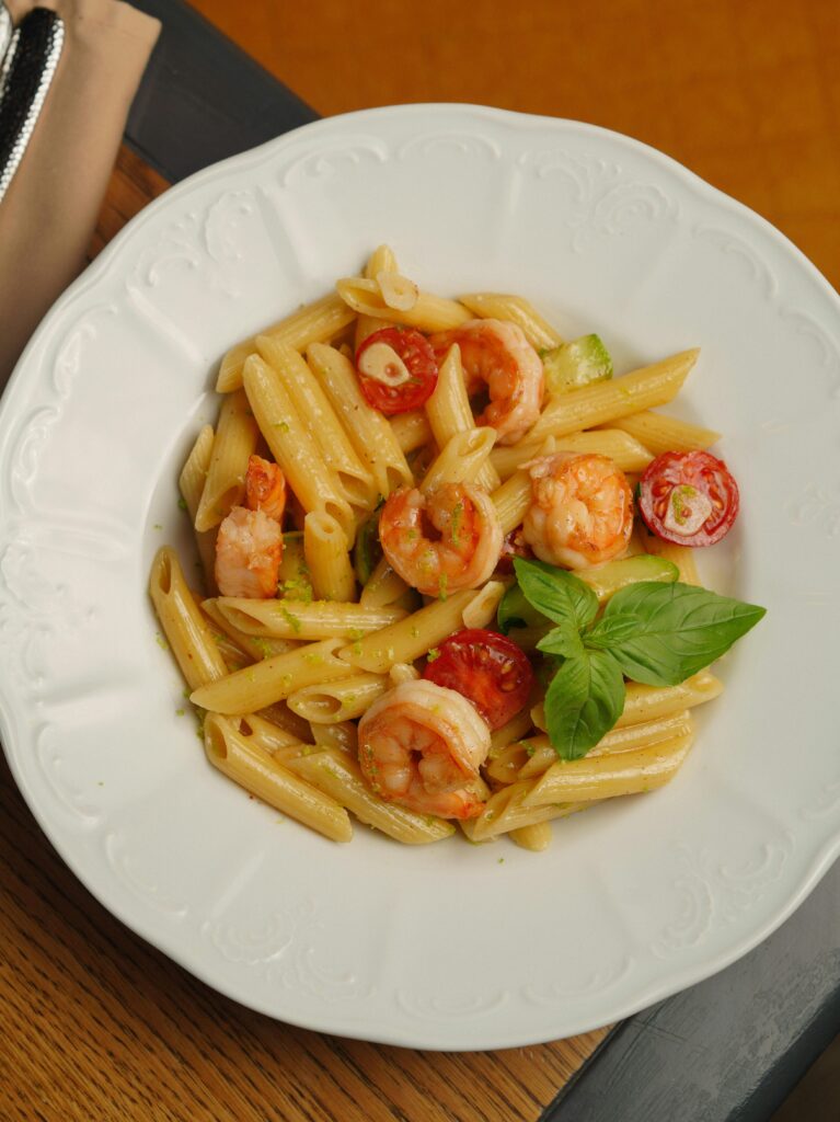 Tasty shrimp penne with cherry tomatoes and basil garnished for a hearty meal.