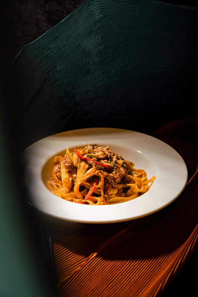 A rustic Italian pasta dish with vibrant colorful vegetables and rich sauce, perfect for gourmet dining.