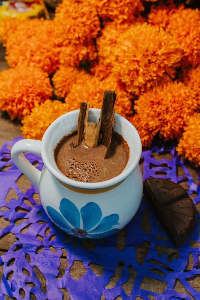 Delicious hot chocolate in a vibrant setting with marigolds for Día de Muertos in Veracruz.