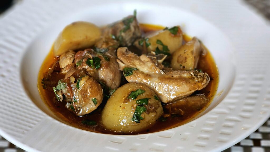 A mouth-watering plate of chicken stew with potatoes and herbs, perfect for a cozy meal.